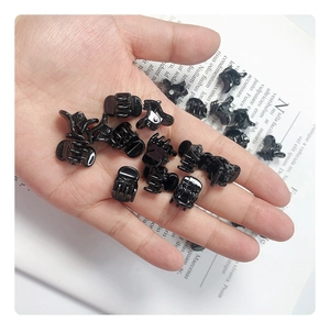 Mini pinces à cheveux noires en plastique montrées en main pour la taille de 1-2 cm
