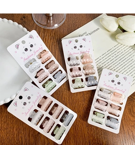 Détail de mini pinces à cheveux papillon mates aux couleurs Morandi sur support