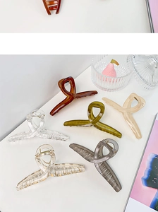 Macro view of six oversized translucent acrylic hair claws in assorted jelly colors