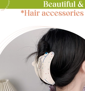 Détail d'une pince à cheveux motif chiot à pois portée sur un chignon coiffé