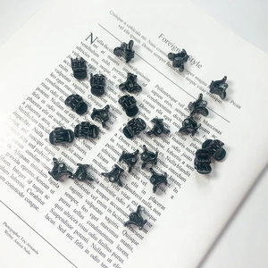 Mini pinces à cheveux en plastique noir pour femmes sur fond de magazine blanc