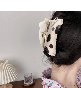 Vue détaillée d'une grande pince à cheveux tachetée en forme de chat sur les cheveux