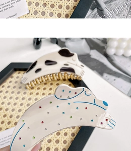 Détail de pinces à cheveux style chien avec motifs à pois et strass colorés brillants