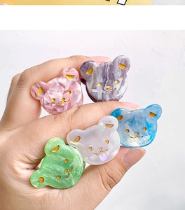 Détail de pinces à cheveux ourson en résine marbrée rose, bleue et violette