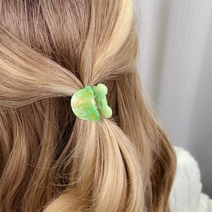 Pince à cheveux ours vert en acétate sur cheveux blonds pour un style doux de fille