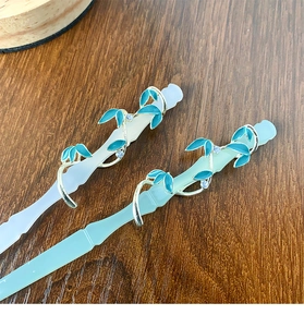 Detalle de horquillas de bambú con hojas doradas y delicados detalles de esmalte azul