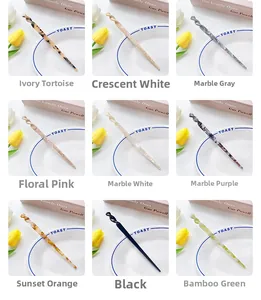 Detail grid of acetate hair sticks in nine marble patterns on a decorative white plate