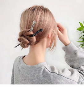 Detail showing two spiral acetate hair sticks in black and grey for bun styling