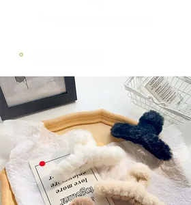 Detailed view of assorted fluffy plush claw clips in soft white, black, and camel colors