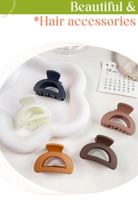 Close-up of five matte Morandi hair clips on a cloud tray with stylish office props