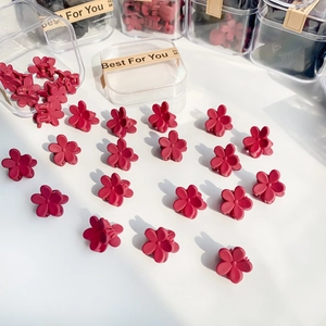 Pack of mini flower hair clips in matte burgundy finish with a clear storage box