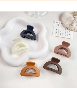 Detail view of five matte mini hair claws in coffee tones on a cloud-shaped tray