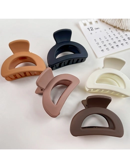 Close-up of minimalist matte hollow hair claws in various earthy tones and colors