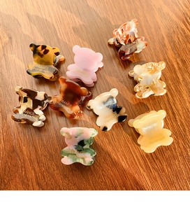 Gros plan de barrettes ours mignonnes en divers motifs d'acétate sur fond de bois