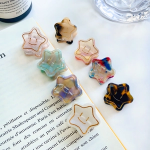 Star-shaped acetate hair claws in assorted marble patterns with smiley face detail