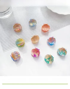 Detailed view of ten colorful shell-shaped mini hair clips with iridescent textures