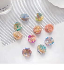 Detail of 10-piece mini shell hair claws with pearlescent gradient finish and gold accents