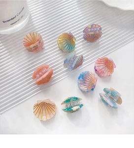 Detailed close-up of colorful mini shell hair claws in multi-color acetate finish