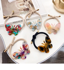 Détail de cinq chouchous papillon en acétate avec texture marbrée et élastiques épais
