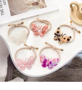 Vue détaillée de cinq chouchous papillon colorés avec texture marbrée sur une table
