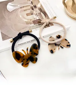 Détail d'élastiques papillon en acétate écaille de tortue avec embouts métalliques dorés