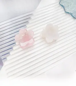Detail of small flower claw clips in pink and white with pearlescent resin finish