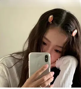 Close-up of marble pattern amber resin hair clips worn on the side by a model
