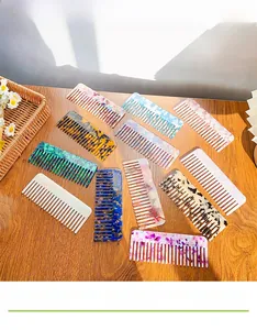 Macro detail of various colorful acetate hair combs with vintage patterns on a wooden table