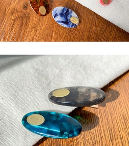 Detail of elegant resin hair clips featuring amber and marble patterns with gold engraving