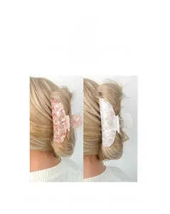 Detail showing pink and white marble acetate hair claws with pearls in a bun hairstyle
