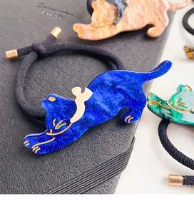 Dettaglio dei ciondoli a gatto in acetato su elastici per capelli con eleganti accenti dorati