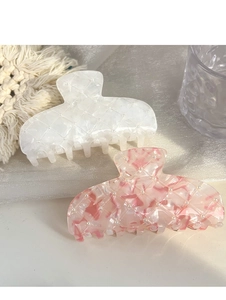Detail of white and pink acetate hair claws with quilted texture and pearl accents