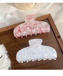 Detailed view of acetic acid hair clips with rhombus texture and pearl accents