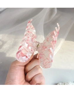 Detailed macro shot of a butterfly acetate hair claw with pink and white marble texture