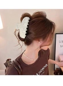 Close-up of white acetate hair claw clip with lattice texture on model's hairstyle