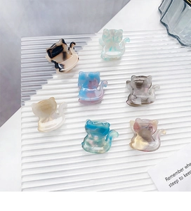 Mini acetate cat-shaped hair clips in tortoiseshell and marble patterns on display
