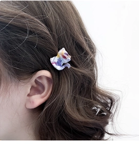 Close-up of a colorful acetate cat hair claw clip on model's brown wavy hair
