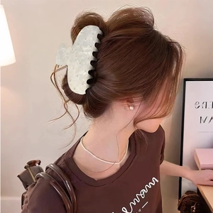 French vintage style large acetate hair claw clip with pearls on model in warm interior