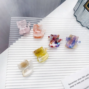 Chic acetate cat hair claws in six marble textures arranged on a wavy glass plate