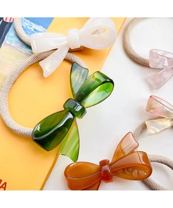 Detailed macro view of colorful acetate bow hair ties with elastic woven ropes