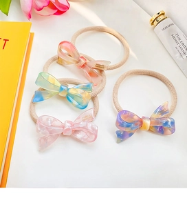 Detail of four high-elastic hair ties with acetate marble texture 3D bow design