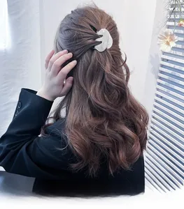 Vue arrière du mannequin portant une pince à cheveux blanche évidée dans une coiffure demi-haute chic