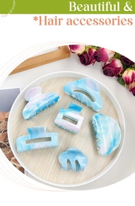 Detail view of sky blue marble pattern hair clips set in acrylic with a glossy finish