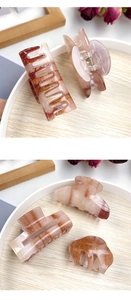 Detail of marble pattern acrylic hair claws showing spring hinge and texture