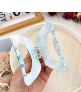 Detail showing marble blue butterfly hair claw clip with internal spring mechanism