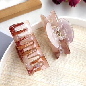 Minimalist acrylic hair claw clips set with marble texture on wooden tray