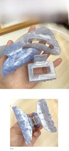 Detailed macro view of large blue marble textured hair claw clips showing premium material
