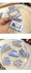 Detail of blue and purple marble texture hair claws with subtle glitter resin finish