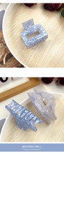 Detail of marble blue acetate hair claws featuring square and wavy geometric designs