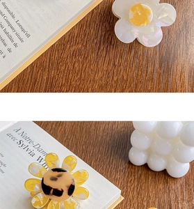 Detail of floral acetate hair claw clips with pearlescent white and sunflower designs